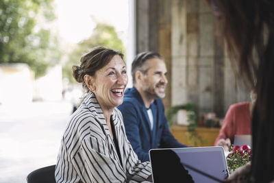 Happy businesswoman sitting with colleagues in portable office truck