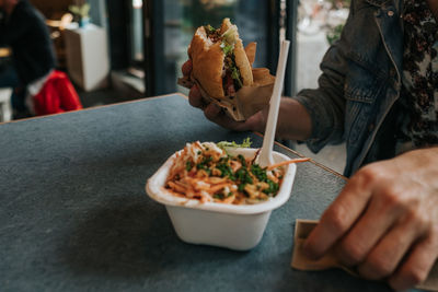 Midsection of man holding food on table