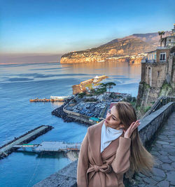 Woman looking at sea against sky