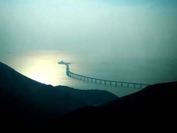 Silhouette of bridge over sea