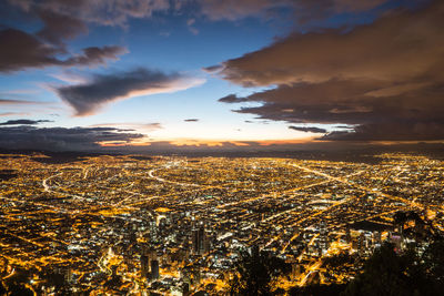 High angle view of illuminated cityscape against sky during sunset