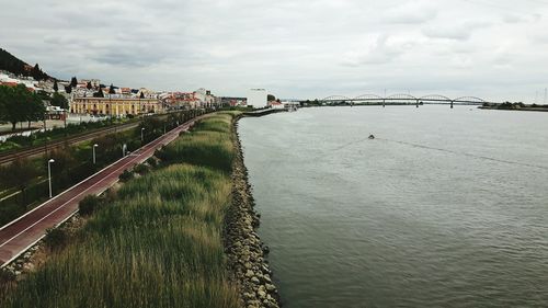 Bridge over river in city against sky