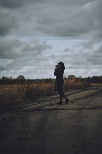 Full length side view of woman standing on field