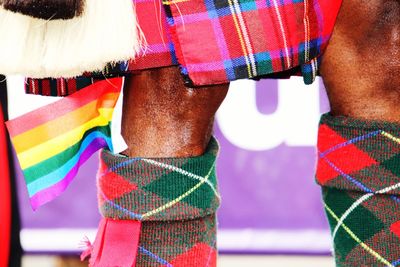 Low section of people standing on multi colored umbrella