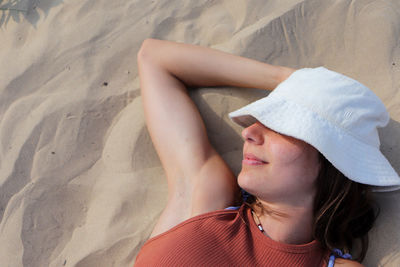 Portrait of young woman sitting at sandy beach
