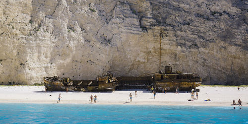 People against shipwreck at beach