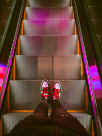 Low section of person standing on escalator