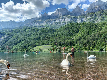 People in lake against mountains