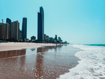 City at waterfront against clear sky