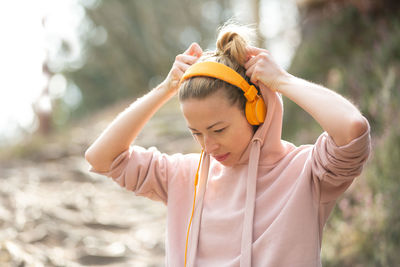 Midsection of woman with arms raised standing in water