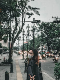 Portrait of woman standing on street in city