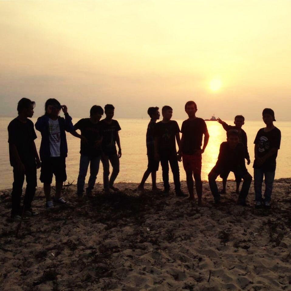 SILHOUETTE OF PEOPLE STANDING ON MOUNTAIN AT SUNSET