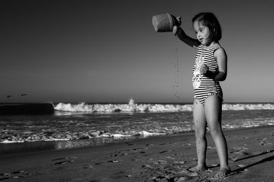 Full length of boy standing on beach against sky