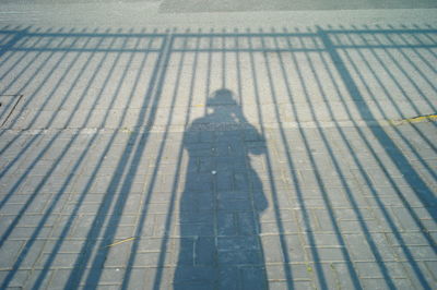 Shadow of person standing on footpath