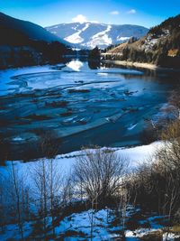 Scenic view of frozen lake by snowcapped mountains