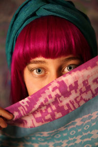 Portrait of woman with pink hair covering face