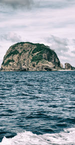 Scenic view of rock formation in sea against sky