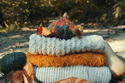 Close-up of pumpkin on stacked warm clothing at field