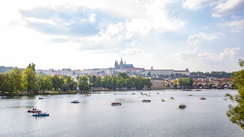 Boats in river with city in background