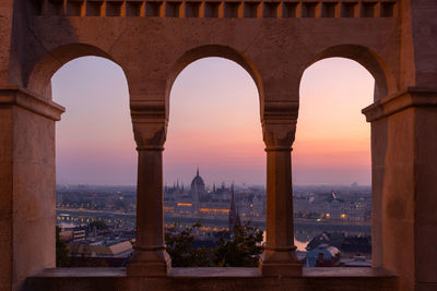 Cityscape seen through window during sunset