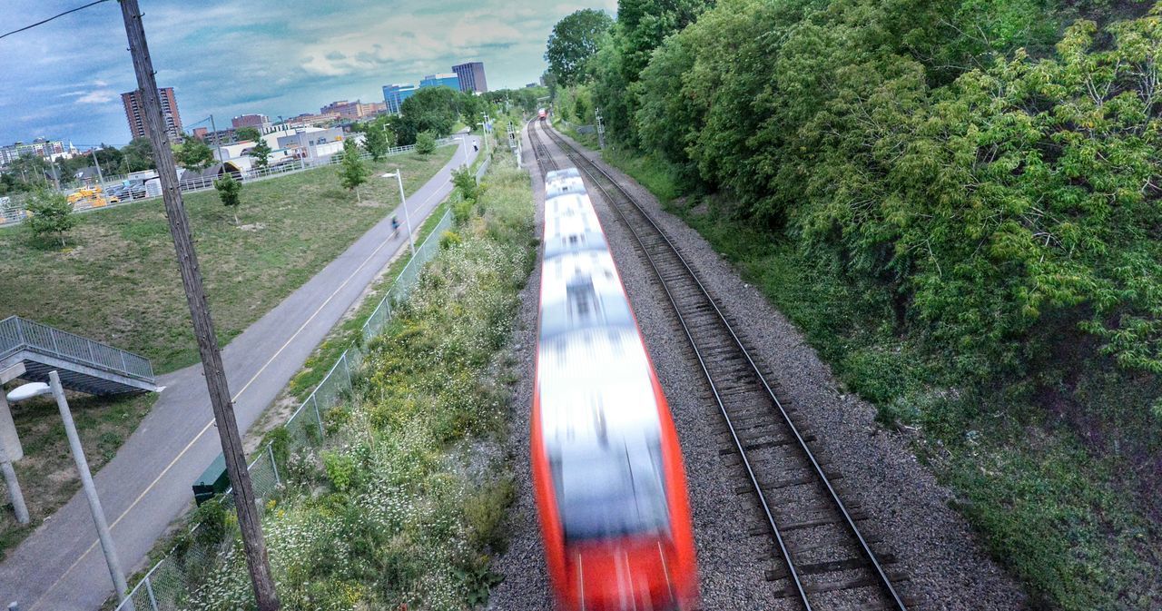 HIGH ANGLE VIEW OF TRAIN MOVING ON ROAD