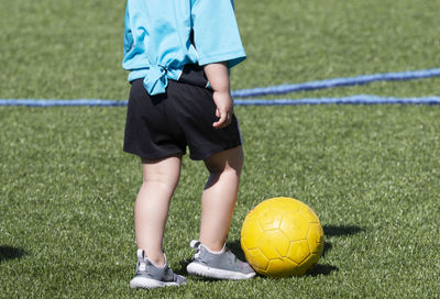 Low section of man playing soccer on field