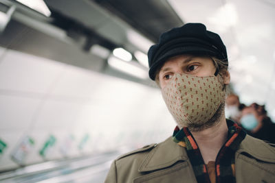 Man going down the escalators in the underground wearing a face mask