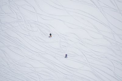 Aerial view of people skiing on snow covered land
