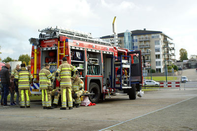 Firefighters standing by engine on city street