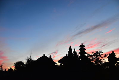 Low angle view of silhouette trees against orange sky