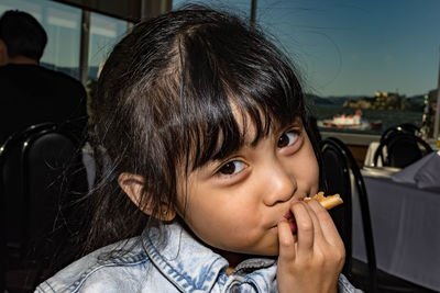 Close-up portrait of cute girl eating food