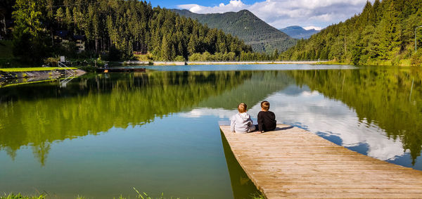 People on lake by mountains
