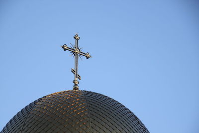 Low angle view of weather vane against blue sky