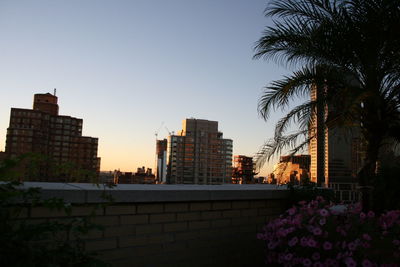 Buildings in city against clear sky