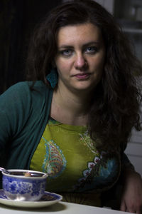 Portrait of woman with coffee cup on table