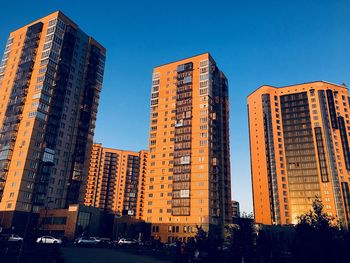 Low angle view of modern buildings against clear blue sky