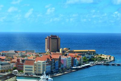 High angle view of sea by buildings against sky