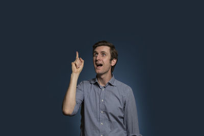 Portrait of smiling man standing against black background