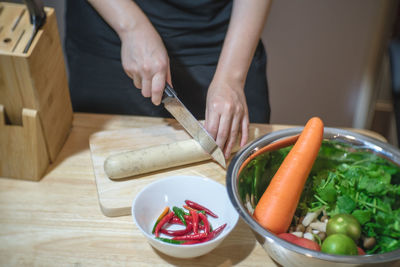 Midsection of man preparing food on cutting board