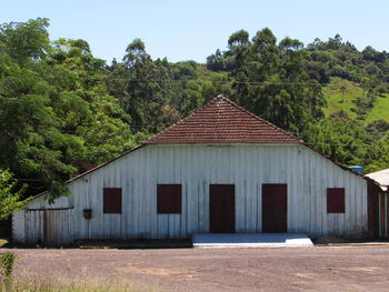 House amidst trees and buildings against sky