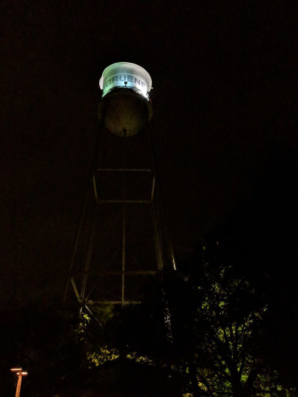 LOW ANGLE VIEW OF ILLUMINATED LIGHTS AGAINST SKY AT NIGHT