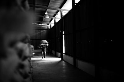 Manual worker carrying sack in factory