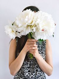 Close-up of woman holding white flower