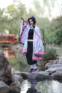 Low section of woman standing against waterfall