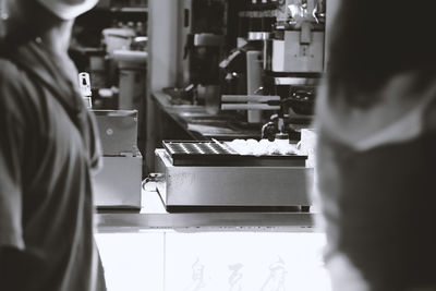 Rear view of people standing in kitchen