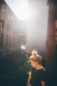 Woman with umbrella in city at sunset