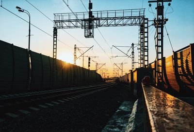 Railroad tracks against sky during sunset