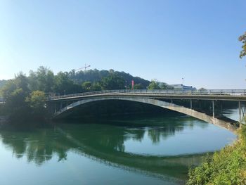 Arch bridge over river against sky