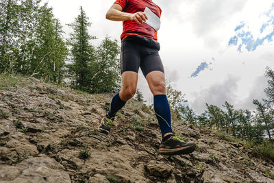 Low section of man standing on rock