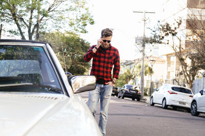 Man wearing plaid shirt and sunglasses while standing on road